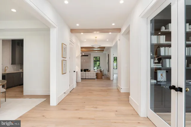 a view of a hallway with wooden floor and a living room