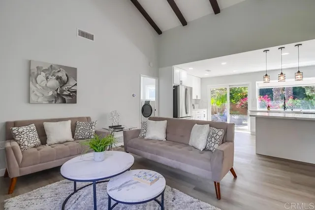 a view of a livingroom with wooden floor and a ceiling fan