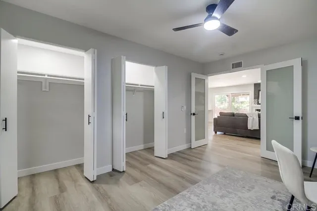 an empty room with fan and windows