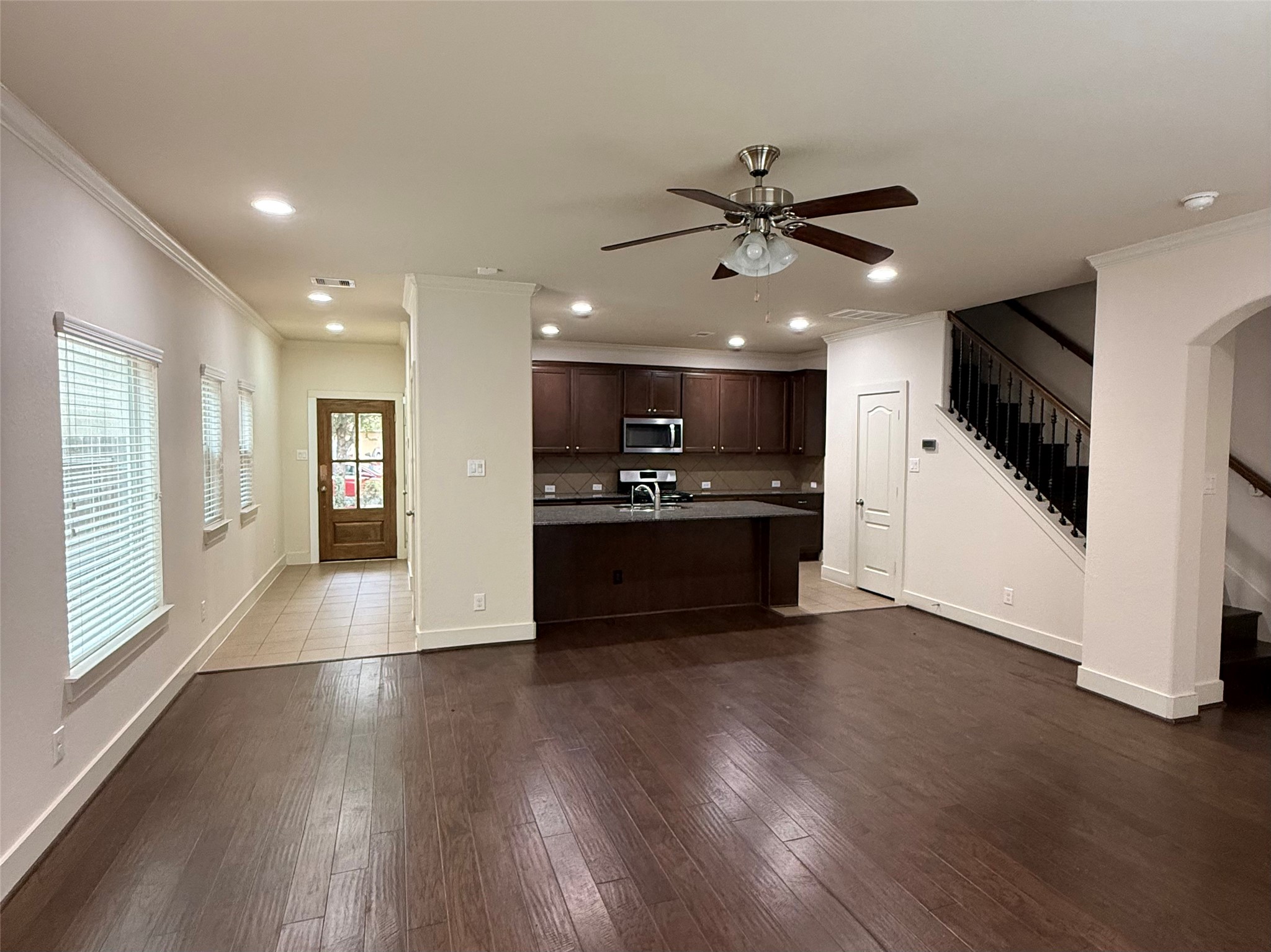 20607 Alfonso Court Spring, TX 77388 - Photo 2 of 25 Wide angle view of living room flowing into kitchen and staircase with wrought iron railing.