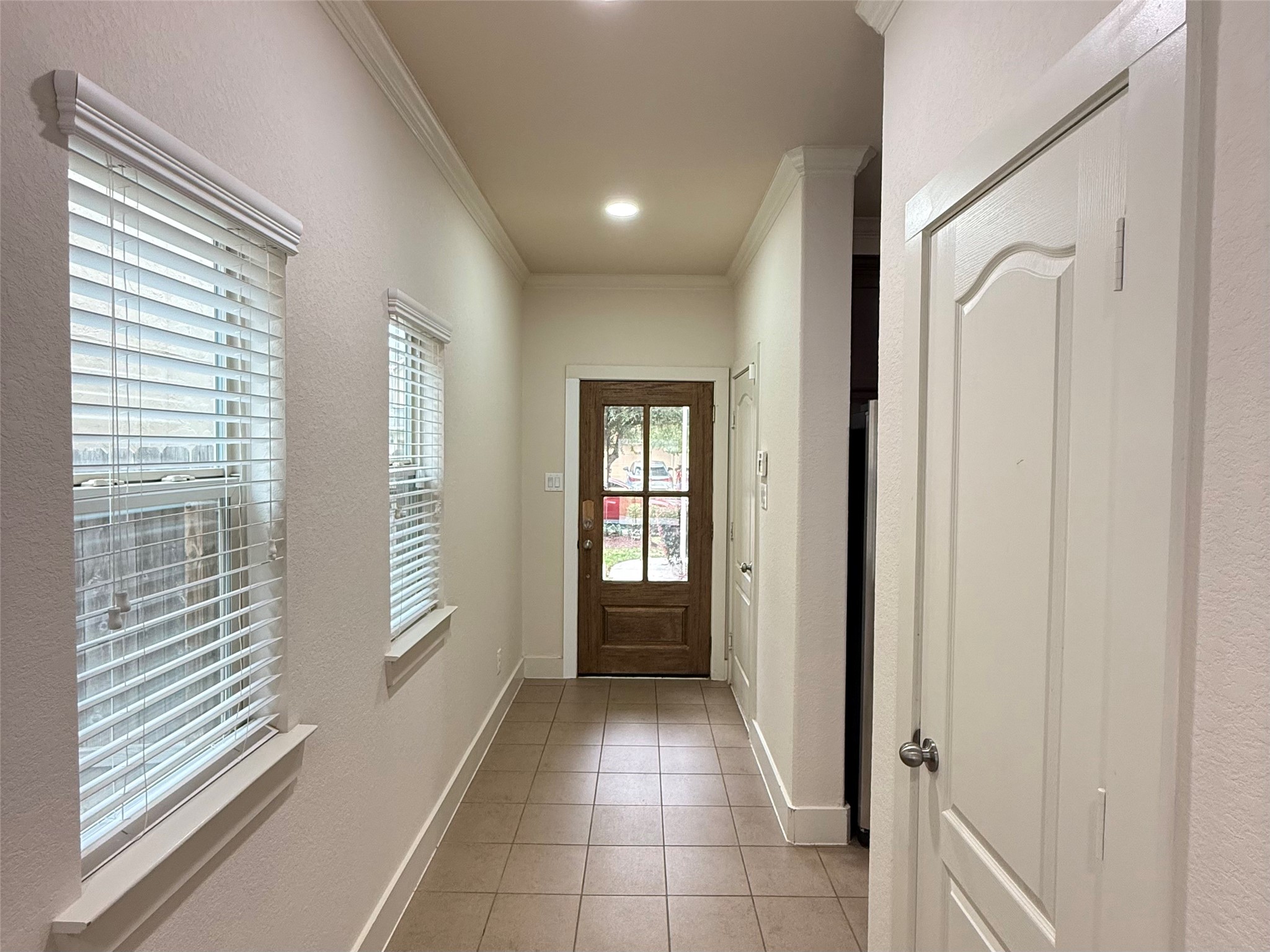 20607 Alfonso Court Spring, TX 77388 - Photo 6 of 25 Bright hallway with tile flooring and natural light leading to entrance.