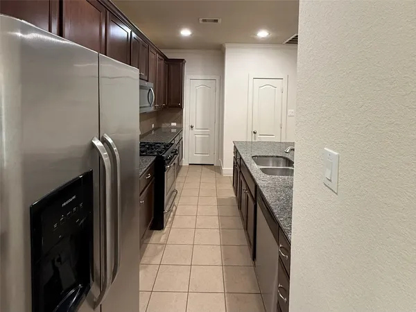 a kitchen with stainless steel appliances granite countertop a refrigerator and a stove
