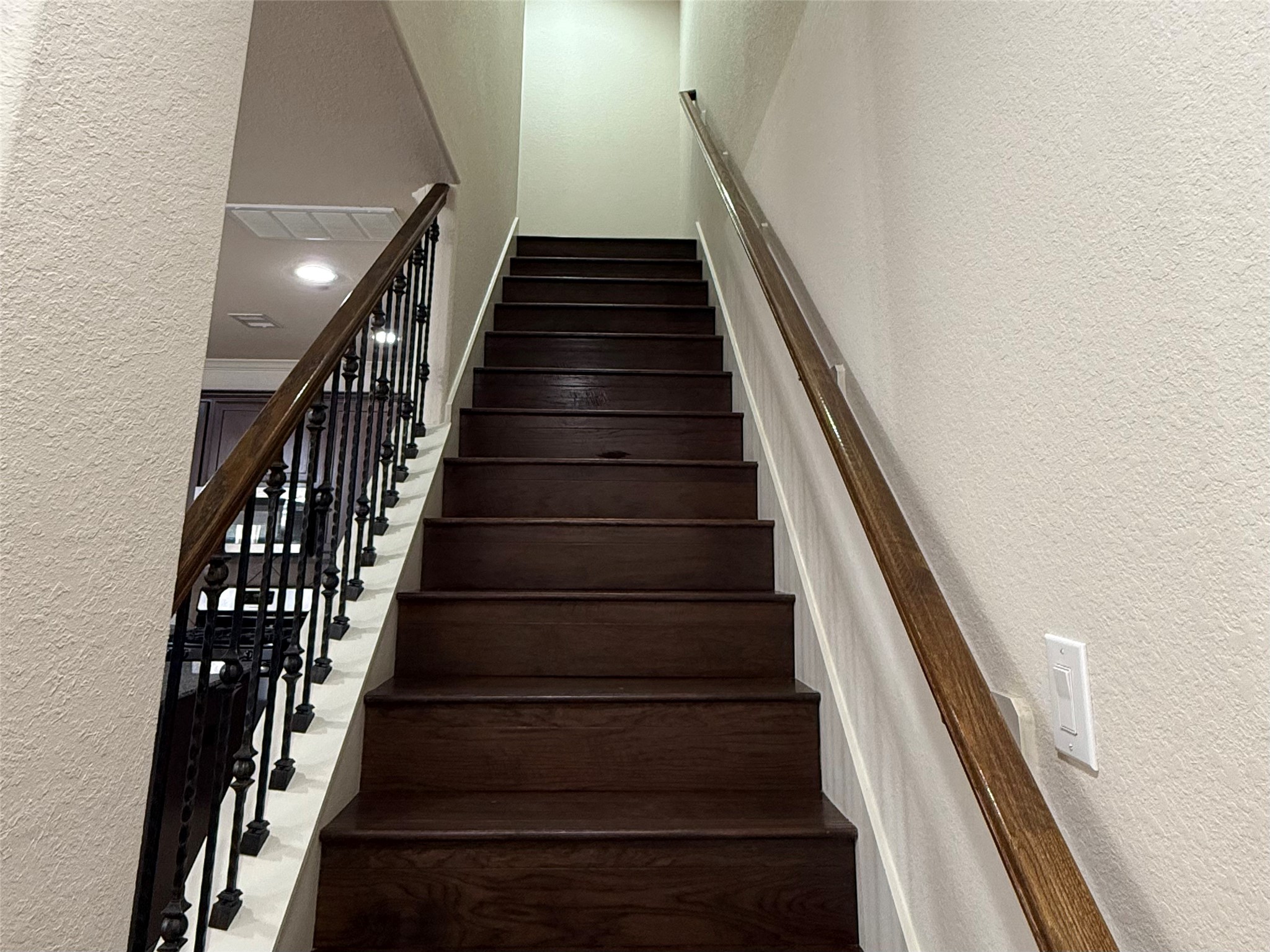 20607 Alfonso Court Spring, TX 77388 - Photo 9 of 25 Stairway with hardwood steps, wood handrail, and wrought iron railing.