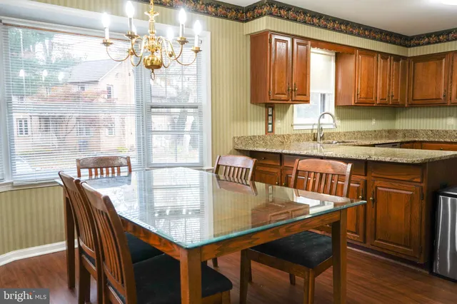 a kitchen with stainless steel appliances granite countertop a stove a refrigerator a kitchen island and chairs in it