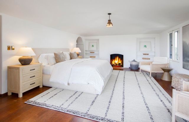 a bedroom with a large bed and a lamp on dresser