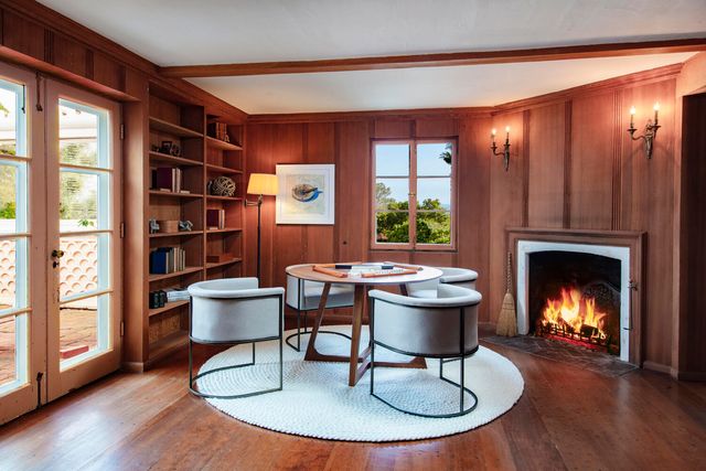 a living room with furniture a fireplace and a floor to ceiling window