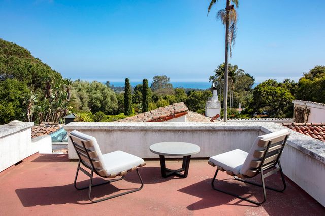 a view of a roof deck with potted plants and sky view