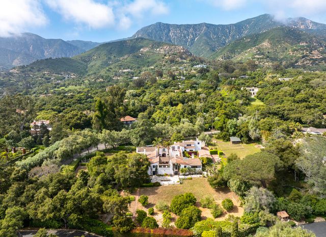 a white house with a yard and a large tree