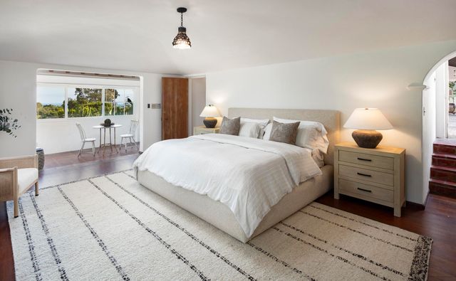 a large white bed in a bedroom and a balcony