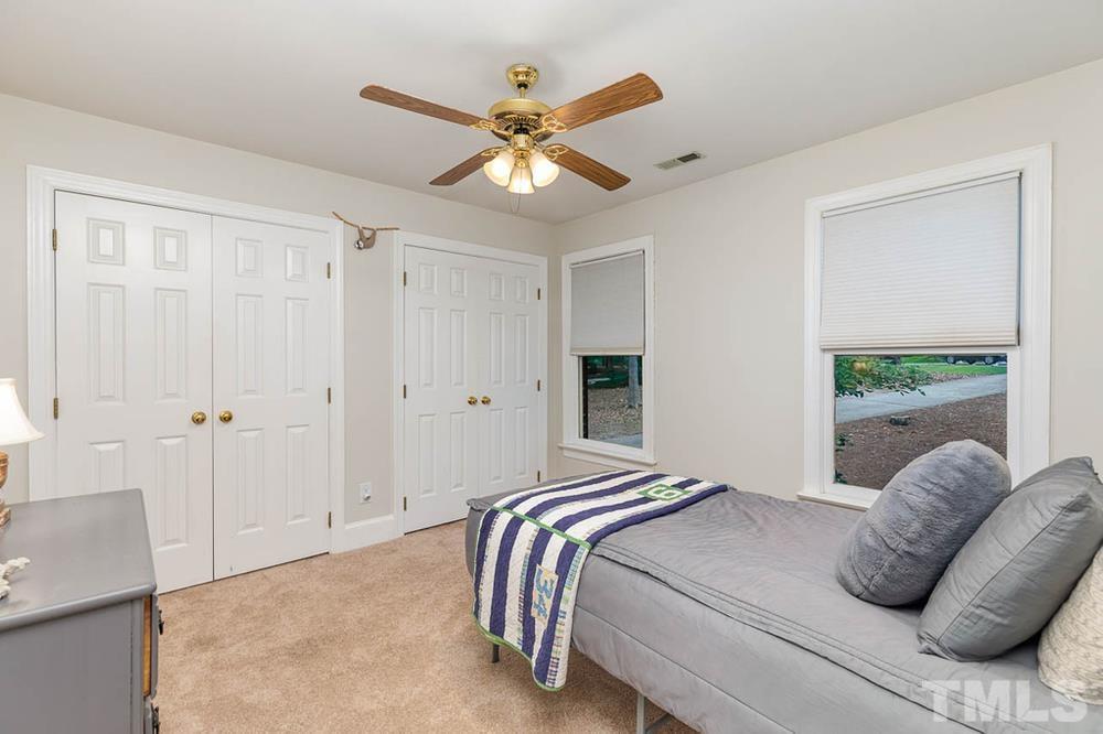 705 Presnell Court Raleigh, NC 27615 - Photo 16 of 30 a bedroom with a large bed and a ceiling fan