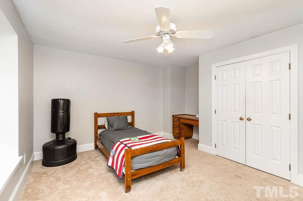 705 Presnell Court Raleigh, NC 27615 - Photo 17 of 30 a bedroom with a bed and a chandelier
