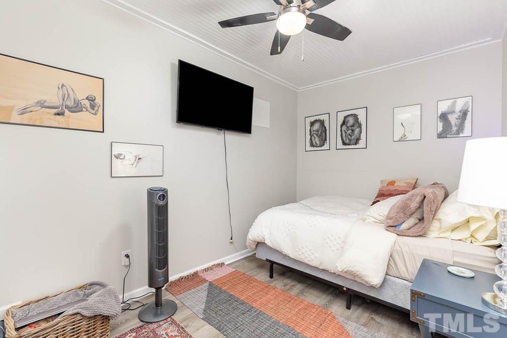 705 Presnell Court Raleigh, NC 27615 - Photo 21 of 30 a bedroom with a bed and a flat screen tv