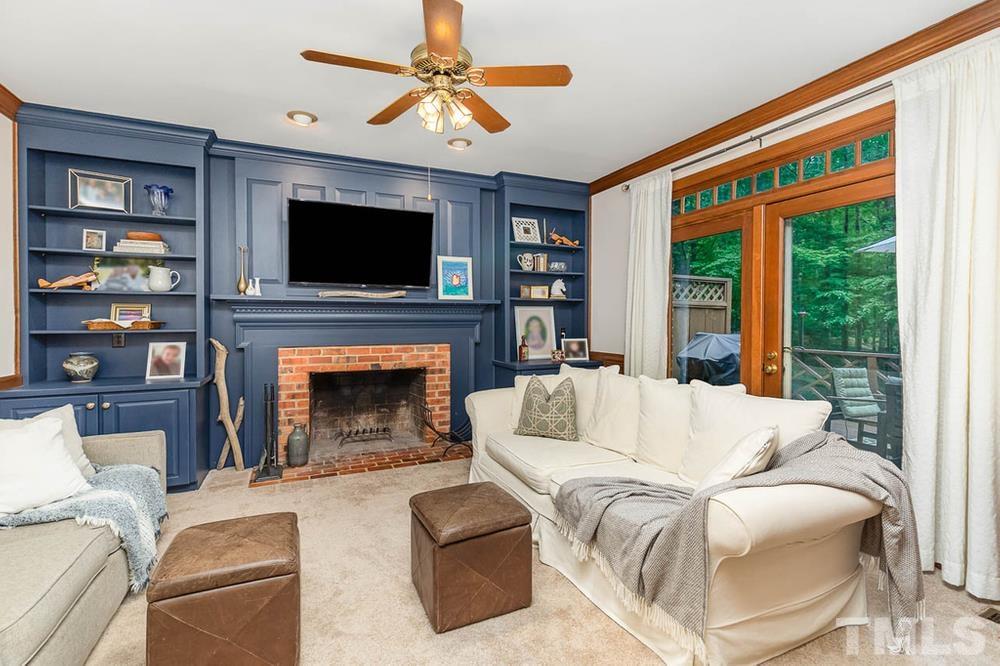 705 Presnell Court Raleigh, NC 27615 - Photo 3 of 30 a living room with furniture a fireplace and a flat screen tv