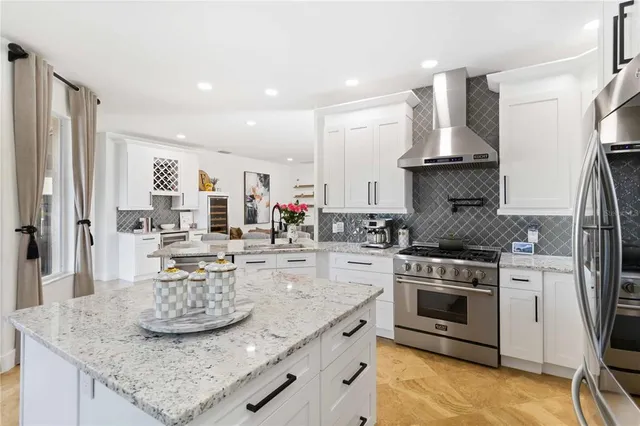 a kitchen with stainless steel appliances granite countertop a sink stove and refrigerator