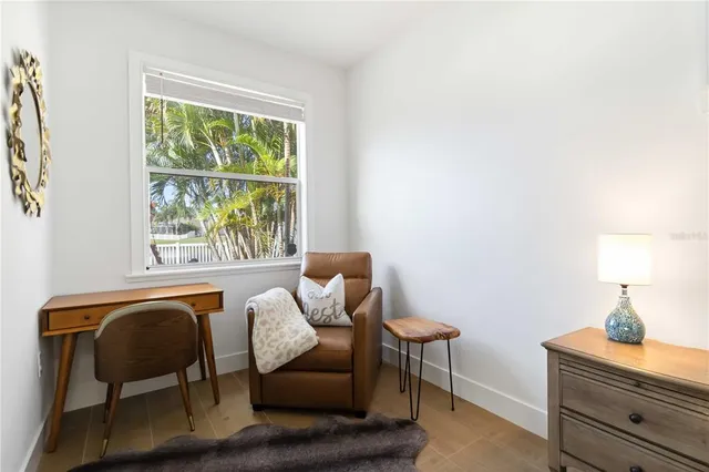a view of a workspace room with furniture and a window
