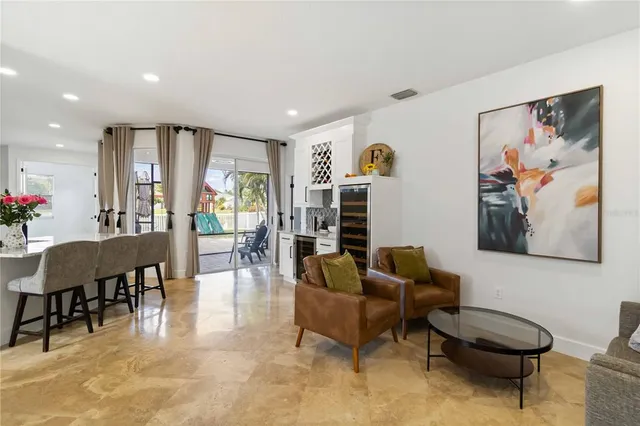 a living room with furniture and a dining table with bookshelf