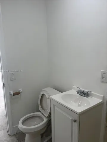 a bathroom with a granite countertop toilet and a sink