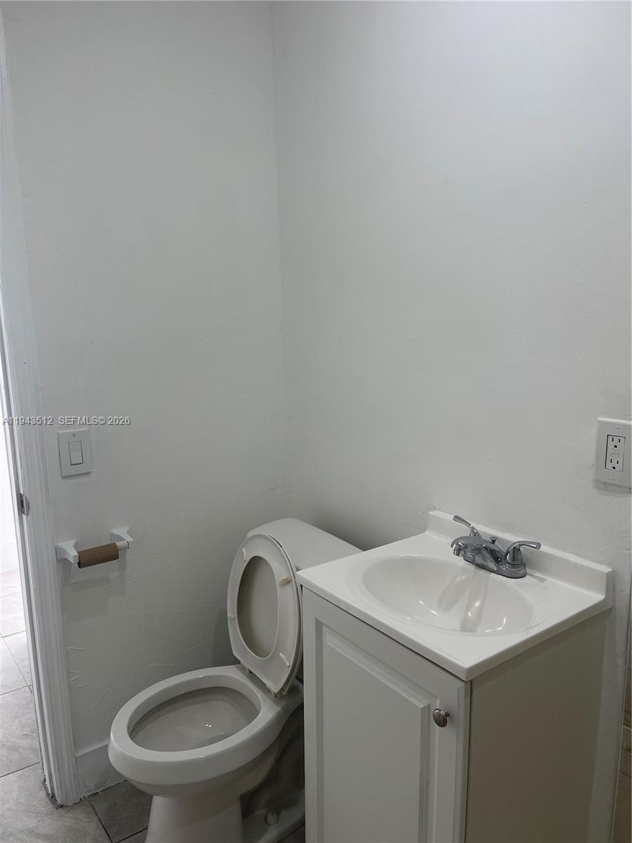 317 East 8th Street, Unit 1 Hialeah, FL 33010 - Photo 11 of 21 a bathroom with a granite countertop toilet and a sink