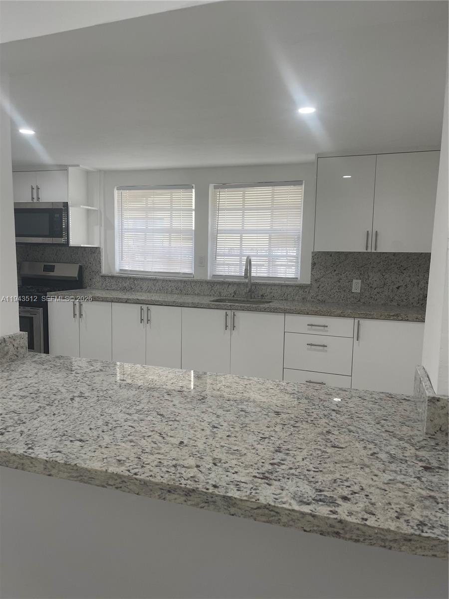317 East 8th Street, Unit 1 Hialeah, FL 33010 - Photo 4 of 21 a kitchen with stainless steel appliances granite countertop a sink and cabinets