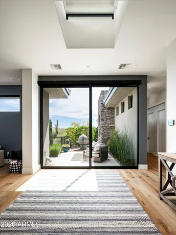 a view of a patio with couches and table and chairs with wooden floor and fence