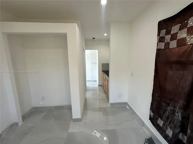 a view of a hallway to rooms and stairs