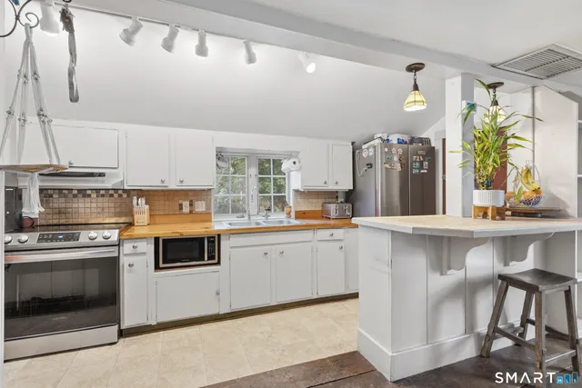 a kitchen with stainless steel appliances a stove a sink and a refrigerator