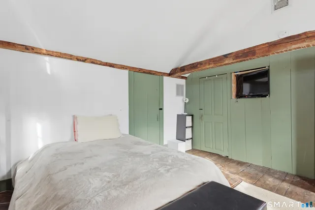 a view of a hallway with a livingroom and wooden floor