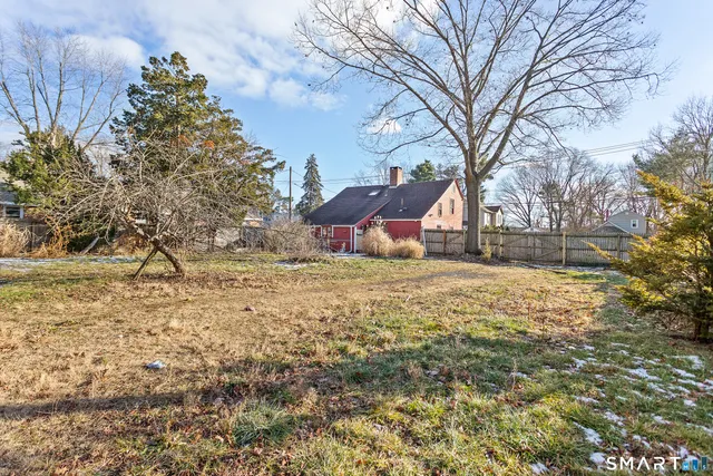 a backyard of a house with large trees and brick walls