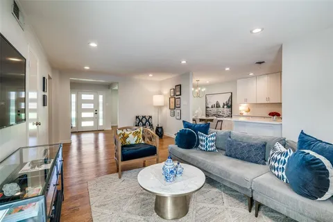 a living room with furniture and a view of kitchen