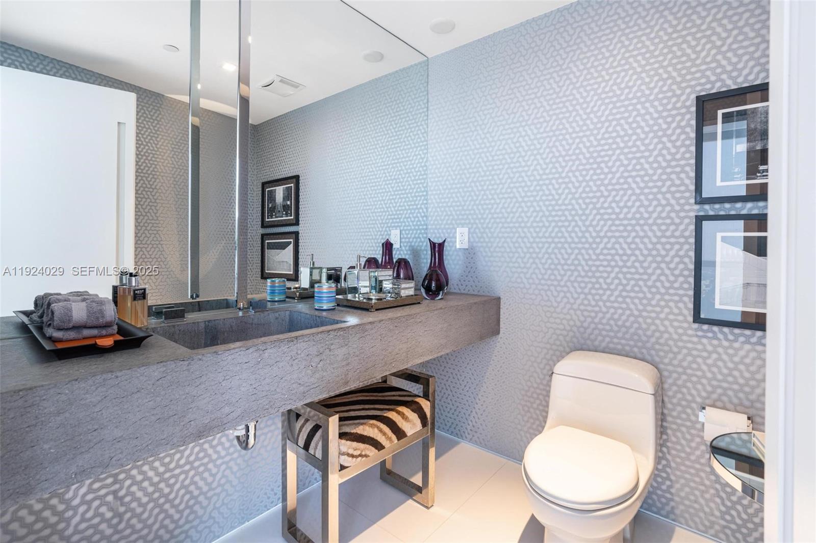 17121 Collins Avenue, Unit 3201 Sunny Isles Beach, FL 33160 - Photo 19 of 36 a bathroom with a toilet a sink and mirror