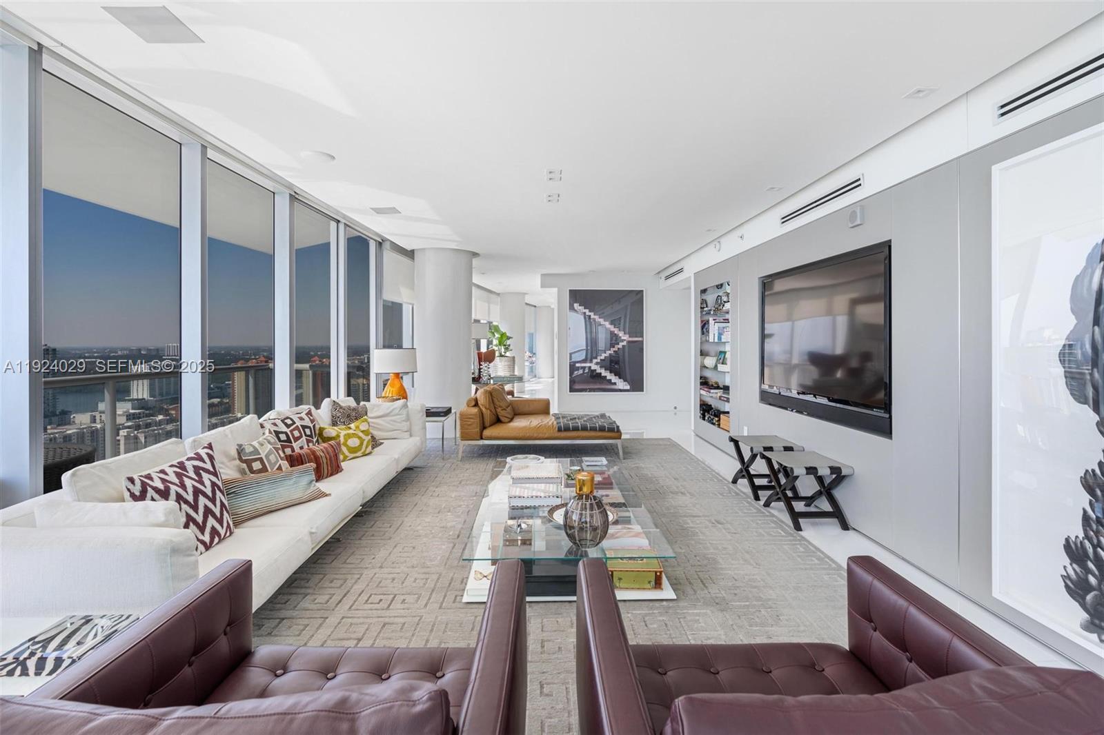 17121 Collins Avenue, Unit 3201 Sunny Isles Beach, FL 33160 - Photo 4 of 36 a living room with furniture and a flat screen tv