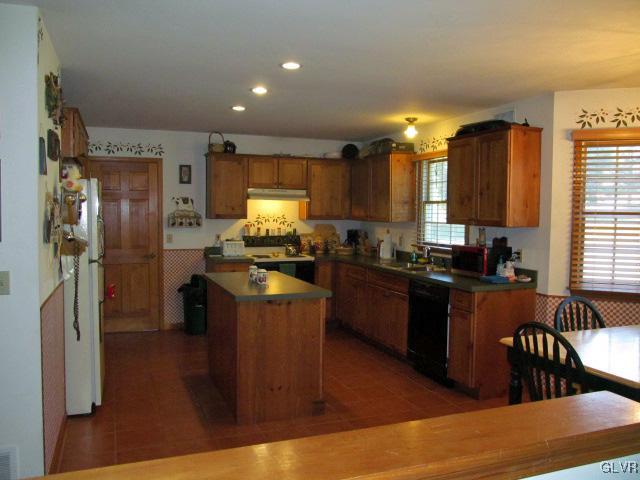 400 Heyer Mill Road Nazareth, PA 18064 - Photo 11 of 27 a kitchen with stainless steel appliances kitchen island granite countertop a refrigerator a stove a sink and a dining table with wooden floor