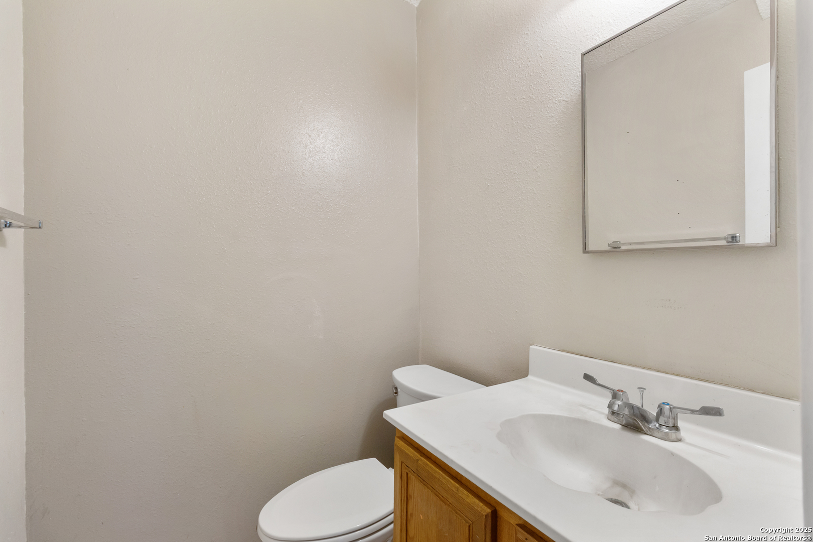 8310 Border Ridge Drive San Antonio, TX 78240 - Photo 12 of 24 a bathroom with a toilet sink and mirror