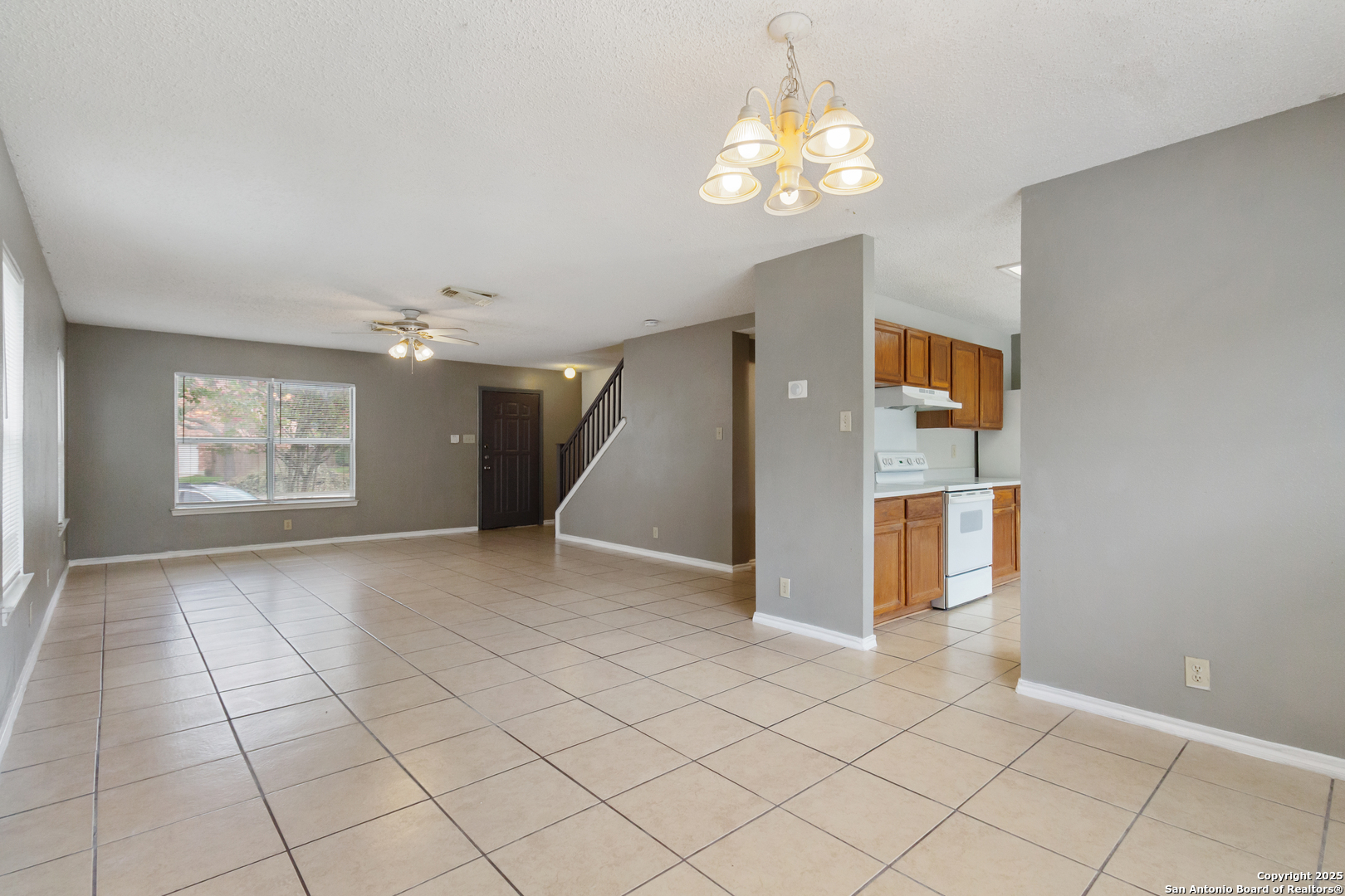 8310 Border Ridge Drive San Antonio, TX 78240 - Photo 7 of 24 an empty room with windows and chandelier