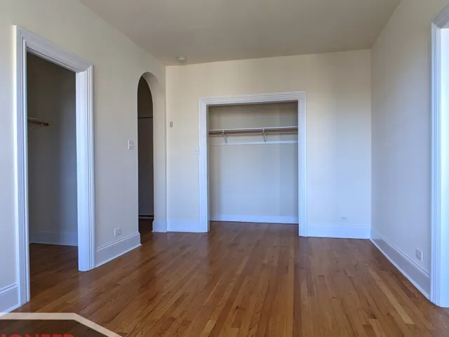 an empty room with wooden floor & closet