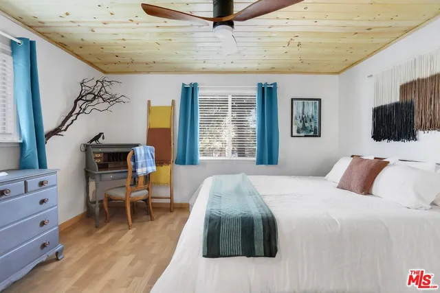 a bedroom with a large bed and a flat tv screen on dresser