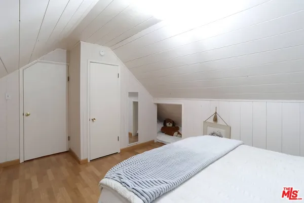 a hallway with a stove a dining table and chairs with wooden floor