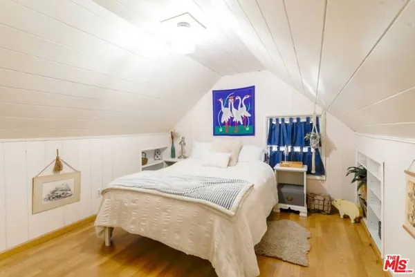 a bedroom with a bed and a painting on the wall