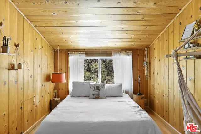 a bedroom with a bed and a dresser with the potted plant