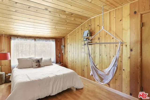 a bedroom with a bed a window and tub