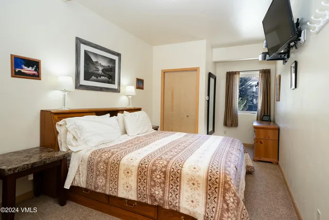 a bedroom with bed and wall painting