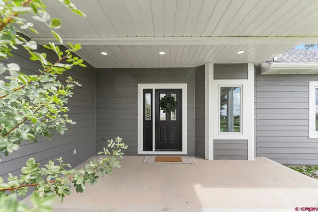 a view of a house with a big yard plants and large trees
