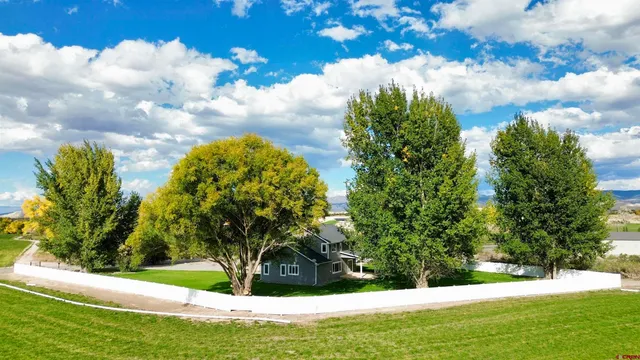 a front view of a house with a yard and a garden