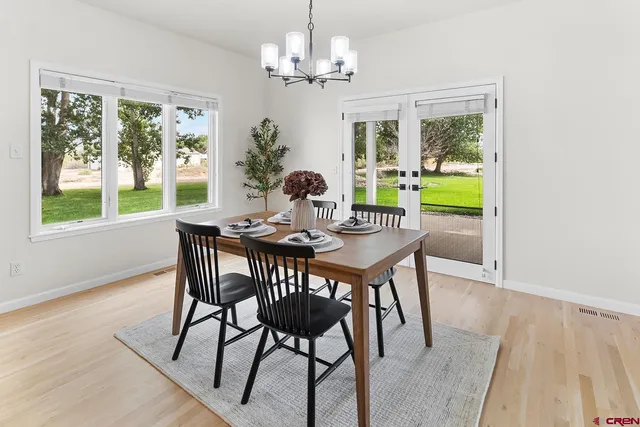 a dining room with furniture a chandelier and wooden floor