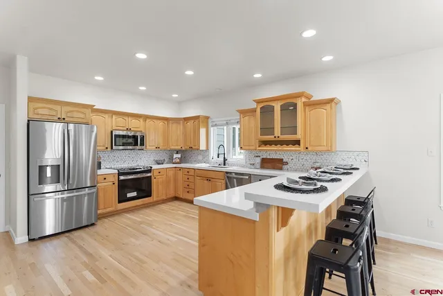 a kitchen with stainless steel appliances granite countertop a stove refrigerator and a sink