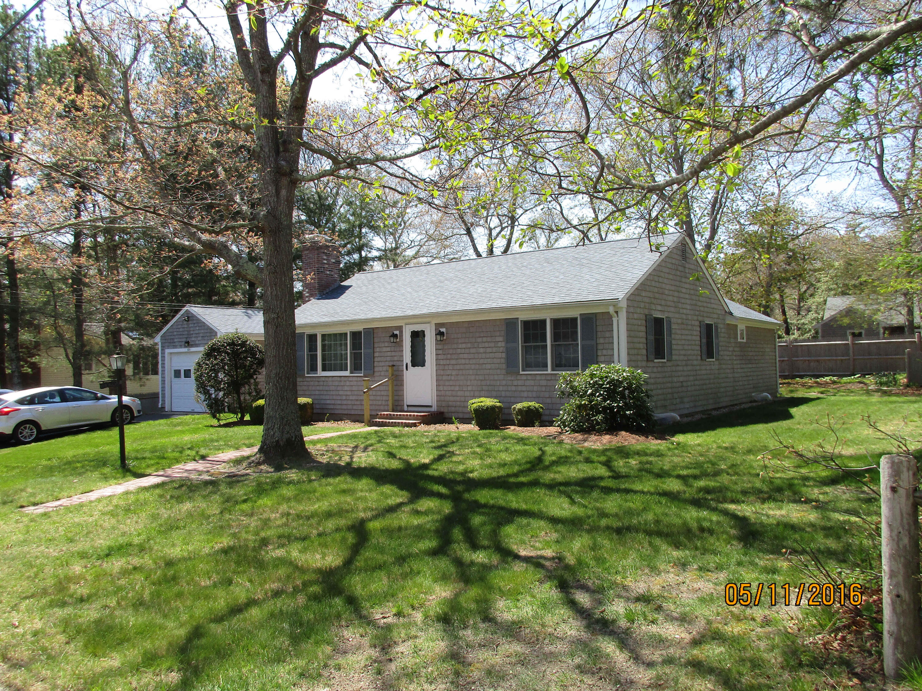 121 Longfellow Drive Centerville, MA 02632 - Photo 1 of 15 a front view of a house with a yard and trees