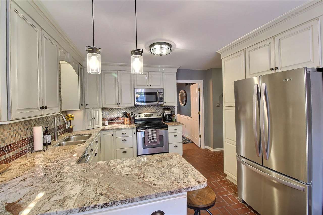 431 King Ridge Drive Collierville, TN 38017 - Photo 9 of 25 a kitchen with granite countertop a refrigerator a stove a sink and white cabinets
