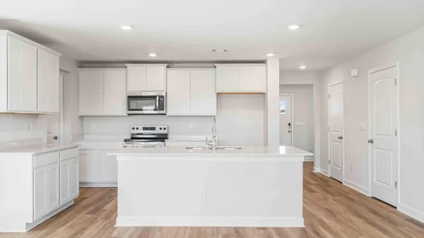 a kitchen with a sink a refrigerator and cabinets