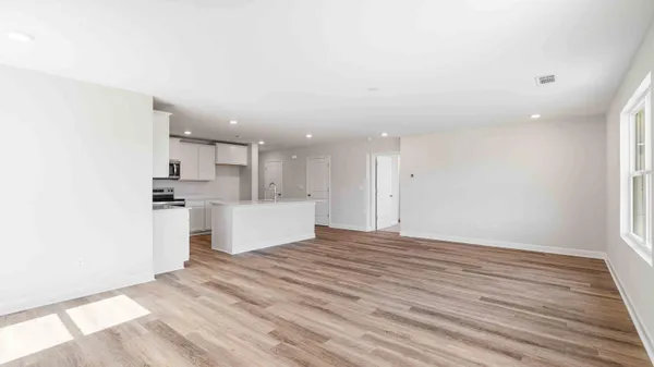a view of a kitchen with white cabinets stainless steel appliances and window