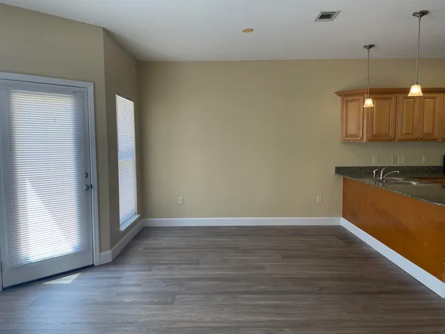 an empty room with wooden floor and a window